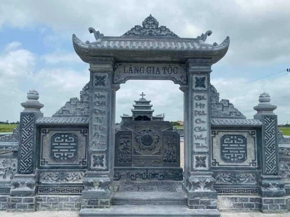 Cổng khu lăng gia tộc bằng đá xanh, khắc chữ "Lăng gia tộc" và câu đối chữ Quốc ngữ trên hai cột