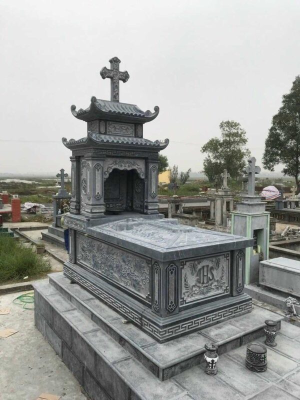 Mộ đá Công giáo bằng đá xanh, thánh giá trên mái, đặt trong nghĩa trang giáo xứ