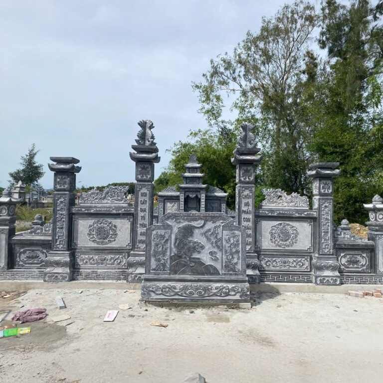 Bình phong cuốn thư đá xanh chạm hoa văn giữa hai trụ cổng khu lăng