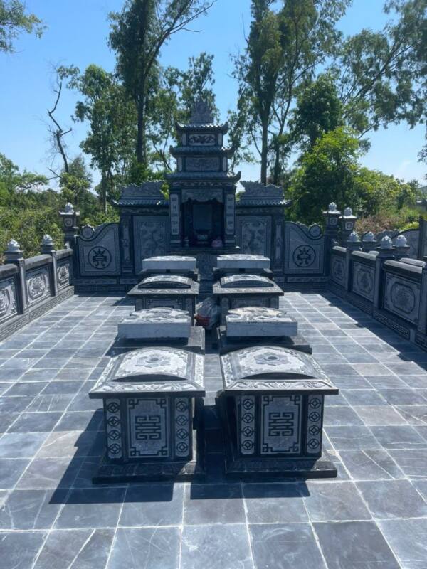 Khu lăng gia đình đá xanh đen có lan can, lăng thờ ba mái và bốn mộ cải táng giữa sân