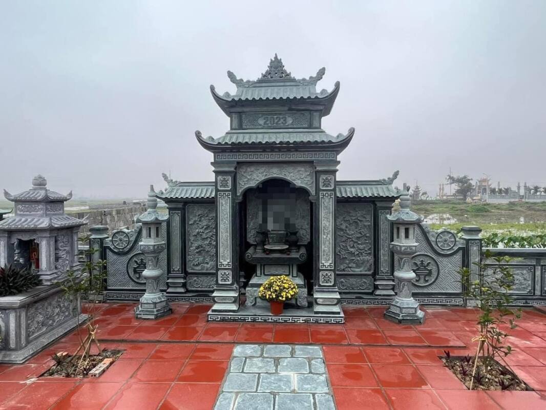 Lăng thờ đá xanh đen hai tầng mái giữa khu lăng, hai bên đèn đá