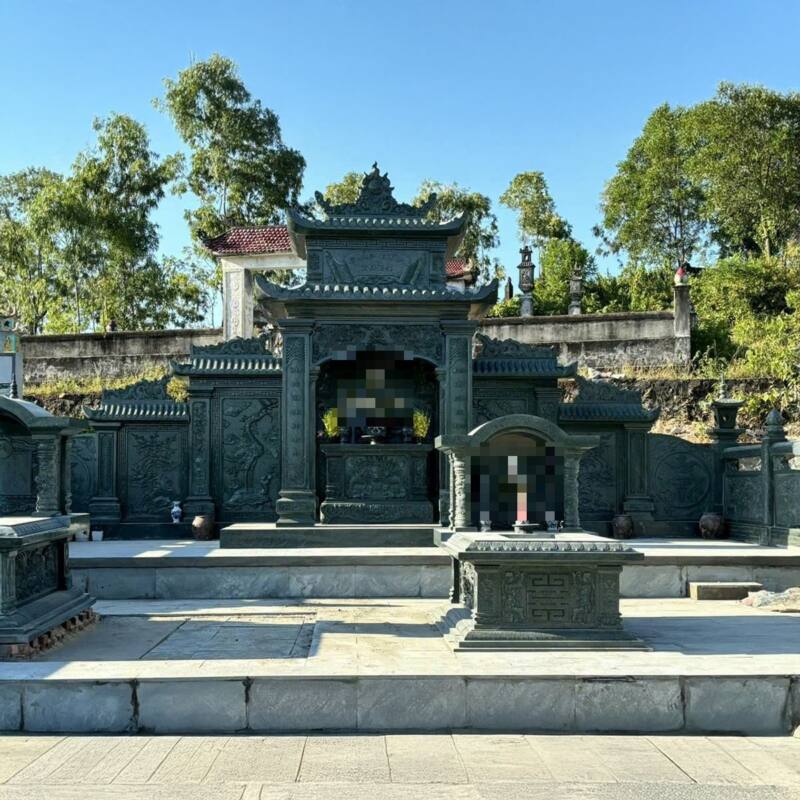 Lăng thờ đá xanh rêu hai tầng mái, tường cánh chạm phong cảnh, mộ tựa vòm cùng màu đá phía trước