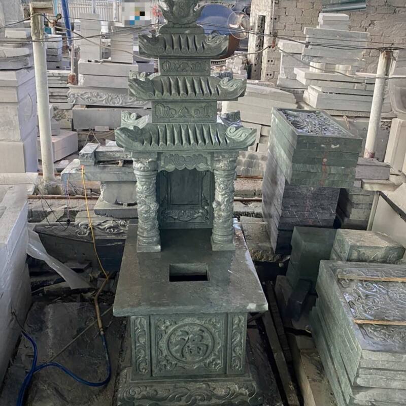 Mộ đá màu xanh rêu ba mái thân gọn, bệ chạm hoa văn tròn, đang hoàn thiện tại xưởng