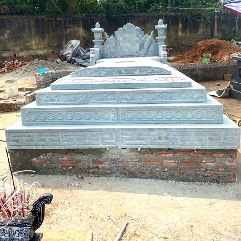 Mộ đá xanh nhiều cấp viền hoa văn chữ triện, đặt trên nền gạch