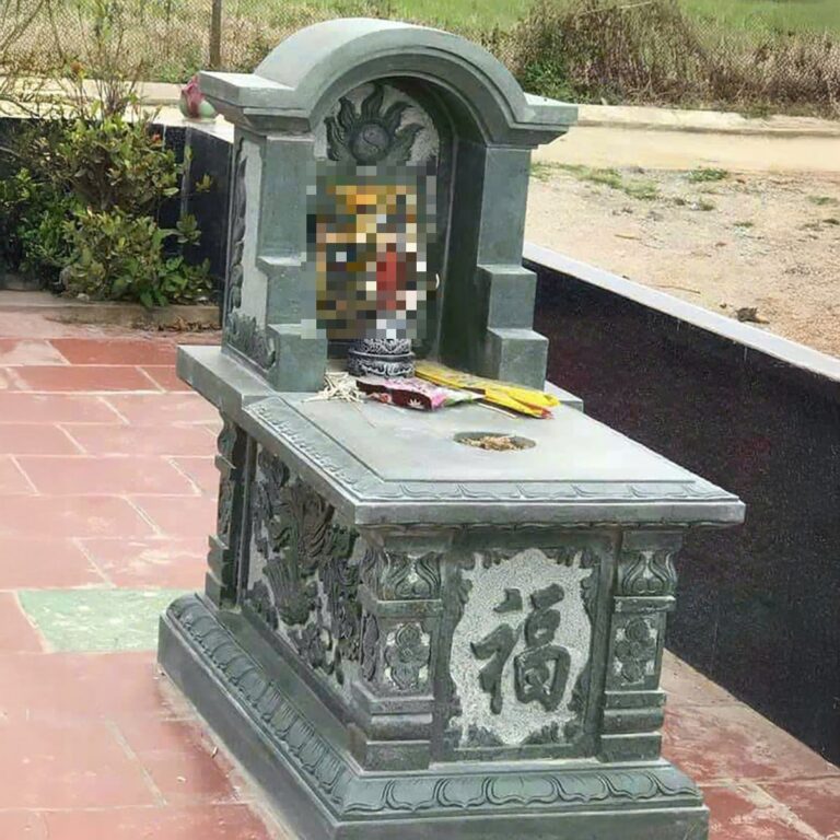 Mộ đá đơn đá xanh tựa vòm, thân chạm chữ Phúc, đặt trên sân gạch